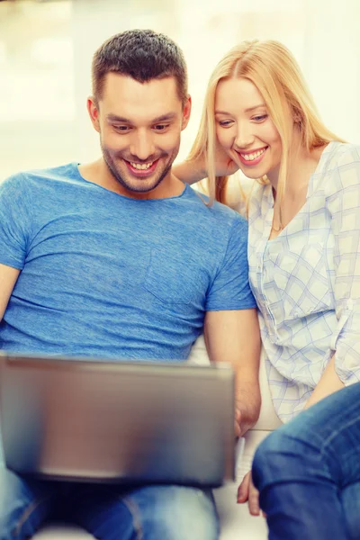 Glimlachend gelukkig paar met laptop thuis — Stockfoto