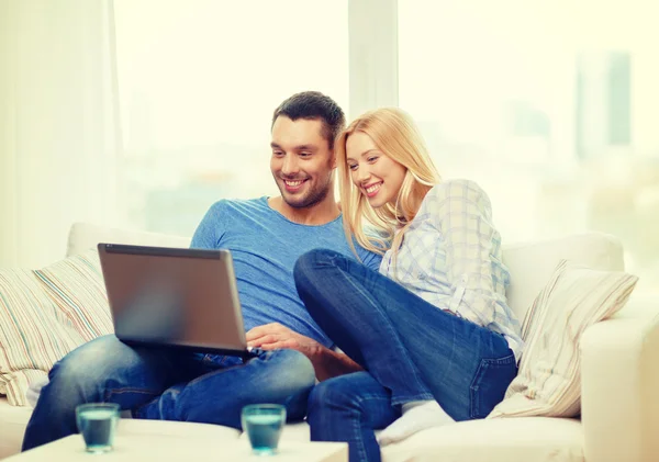 Sonriente feliz pareja con portátil en casa —  Fotos de Stock