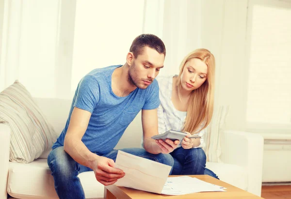 Couple occupé avec papiers et calculatrice à la maison — Photo