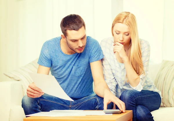 Geschäftiges Paar mit Papieren und Taschenrechner zu Hause — Stockfoto