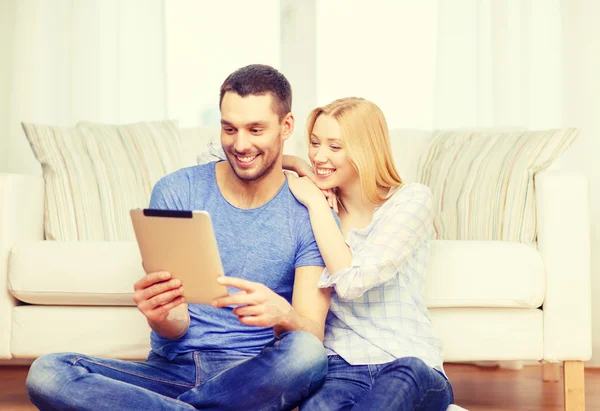 Sorrindo casal feliz com tablet pc em casa — Fotografia de Stock