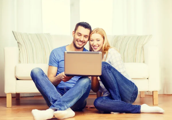 Sorridente coppia felice con computer portatile a casa — Foto Stock