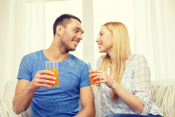 Sorrindo casal feliz em casa beber suco — Fotografia de Stock