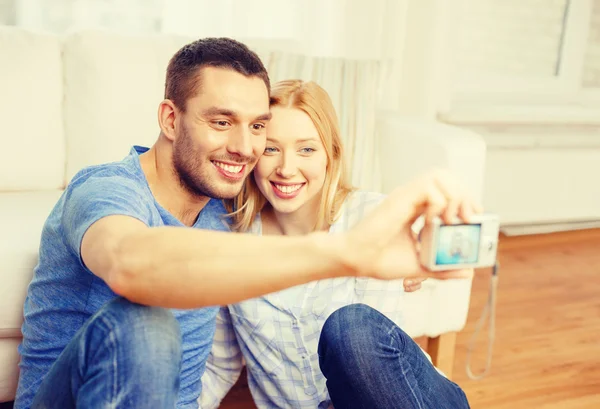 Sonriente pareja tomando fotos con cámara digital — Foto de Stock