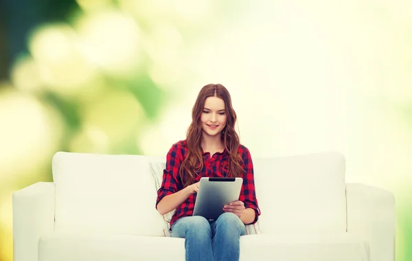 十几岁的女孩坐在沙发上与平板电脑 — 图库照片