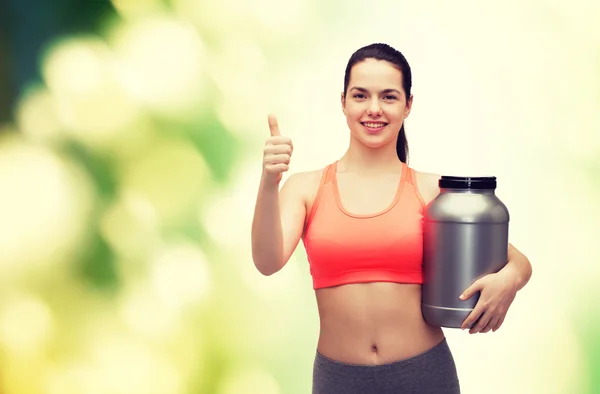 Tienermeisje met pot van eiwit duimen opdagen — Stockfoto