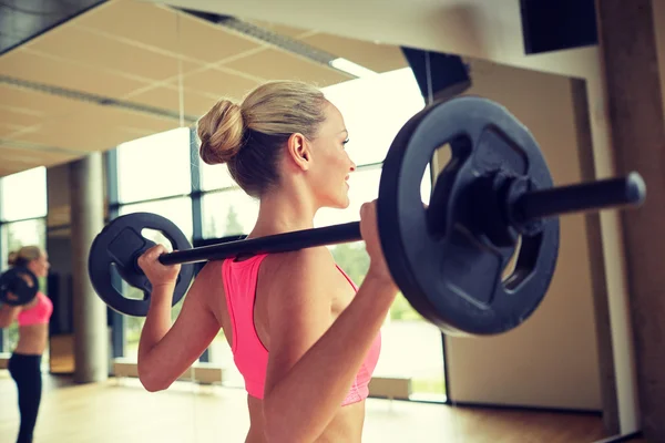 Sportieve vrouw oefenen met lange halter in de sportschool — Stockfoto