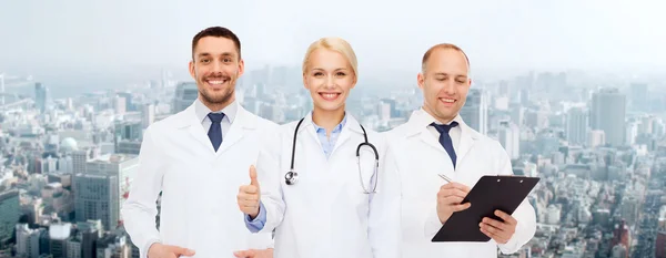 Grupo de médicos mostrando los pulgares hacia arriba sobre blanco — Foto de Stock