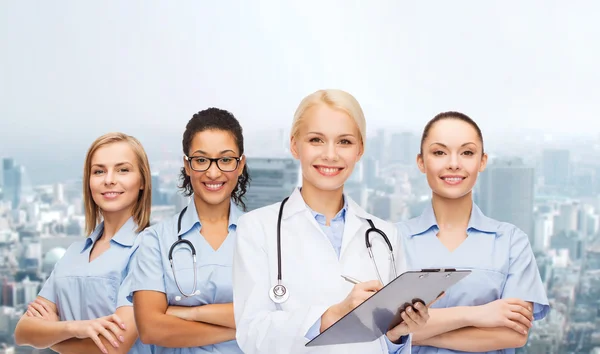 Smiling female doctor and nurses with stethoscope — Stock Photo, Image