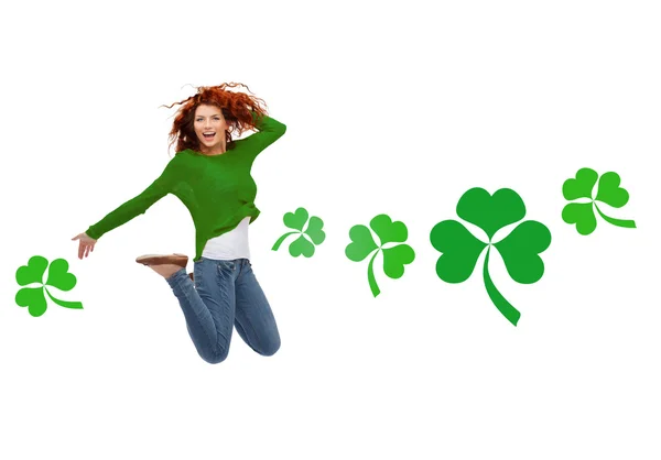 Lächelndes Teenie-Mädchen springt mit Shamrock in die Luft — Stockfoto