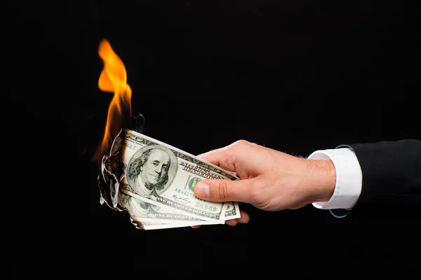 Närbild på manliga hand innehav brinnande dollar pengar — Stockfoto