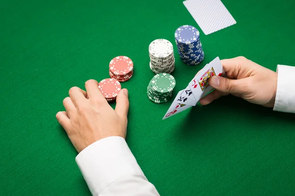 Joueur de poker avec des cartes et des jetons au casino — Photo