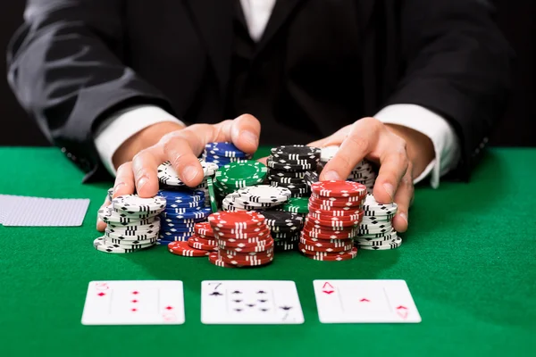 Jugador de poker con cartas y fichas en el casino — Foto de Stock