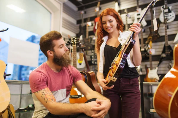 Pareja de músicos con guitarra en tienda de música —  Fotos de Stock