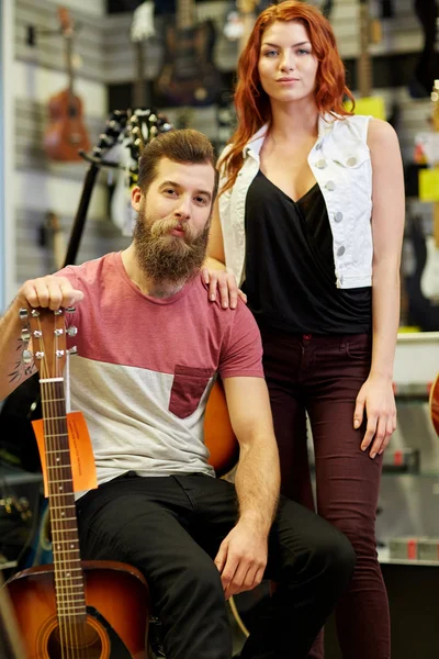 Couple of musicians with guitar at music store — Stock Photo, Image