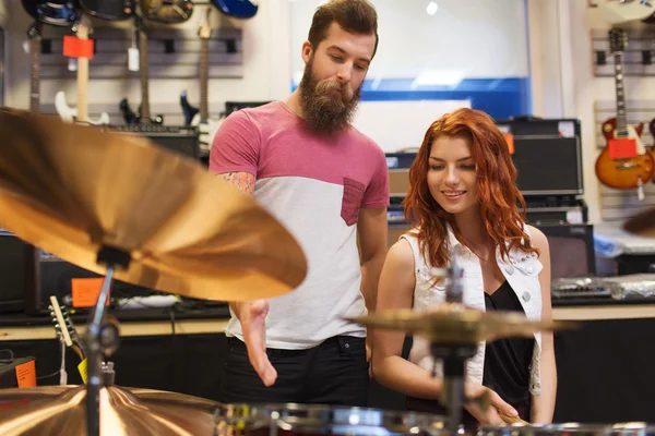 Man and woman with drum kit at music store — Stock Photo, Image