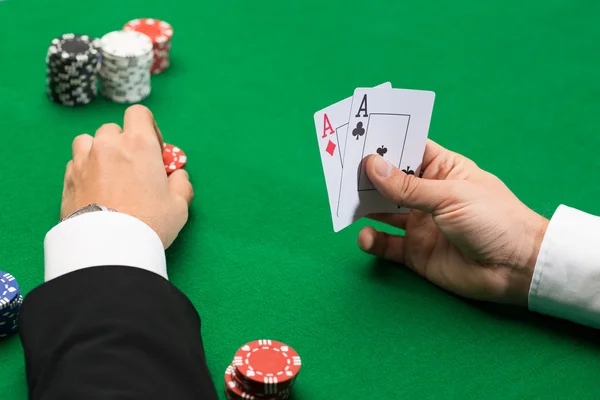 Игрок в покер с картами и фишками в казино — стоковое фото