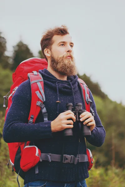 Man med ryggsäck och kikare utomhus — Stockfoto