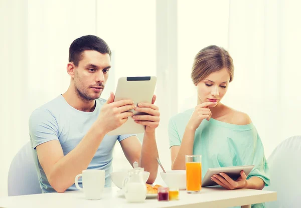 Paar geconcentreerd met tablet pc lezen van nieuws — Stockfoto