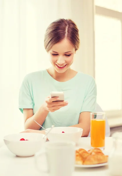 Usměvavá mladá žena s smartphone čtení zprávy — Stock fotografie