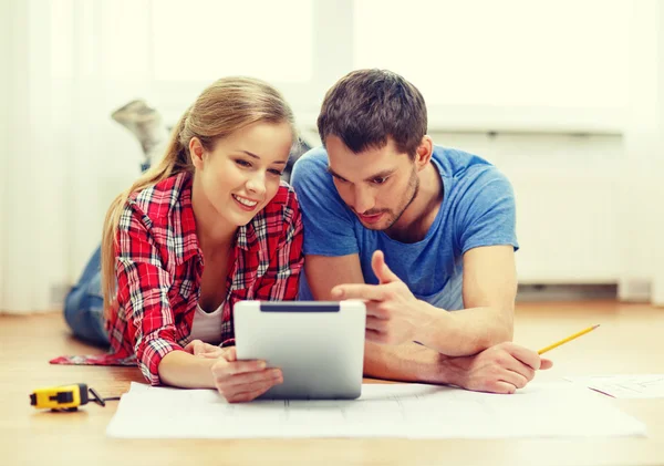 Para uśmiechający się patrząc na komputerze typu tablet w domu — Zdjęcie stockowe