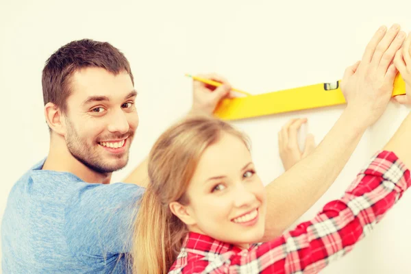 Couple building using spirit level to measure — Stock Photo, Image