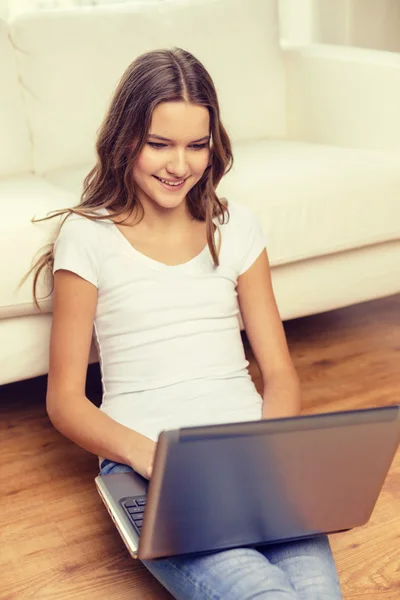 Sonriente adolescente con ordenador portátil en casa — Foto de Stock