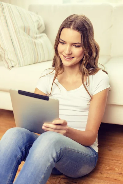 Lächelndes Teenager-Mädchen mit Tablet-PC zu Hause — Stockfoto