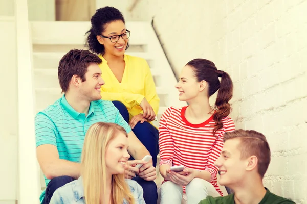 Lachende studenten met smartphone discussie — Stockfoto