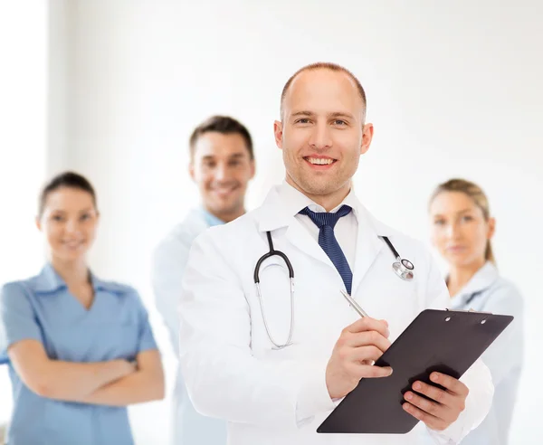 Sorridente médico masculino com prancheta e estetoscópio — Fotografia de Stock