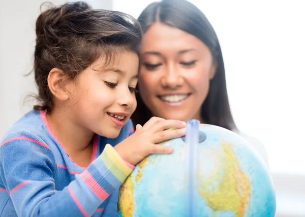 Mother and daughter with globe — Stock Photo, Image