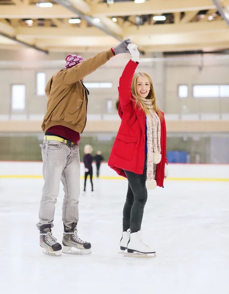 Happy couple holding hands on skating rink — Stock Photo, Image