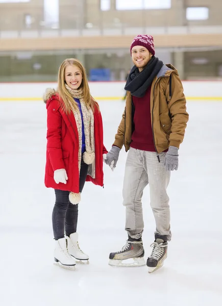 Feliz pareja cogida de la mano en pista de patinaje — Foto de Stock