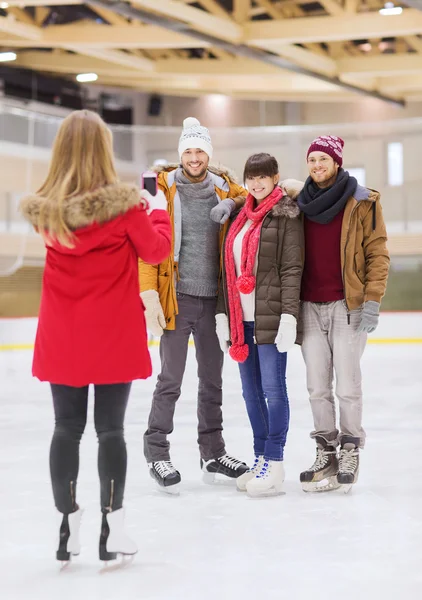 Amigos felices tomando fotos en pista de patinaje — Foto de Stock