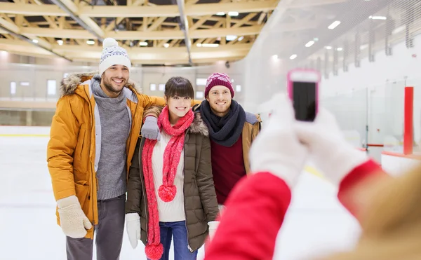 Happy friends taking photo on skating rink — Stock Photo, Image