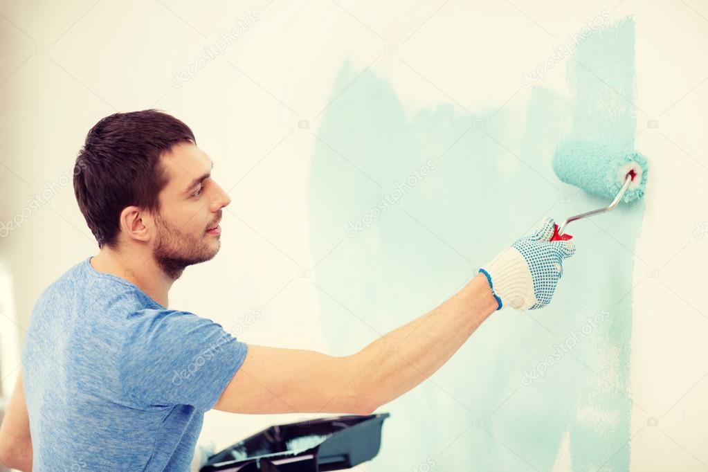 Smiling man painting wall at home Stock Photo by ©Syda_Productions 61892347