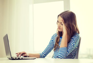 upset teenage gitl with laptop computer at home clipart