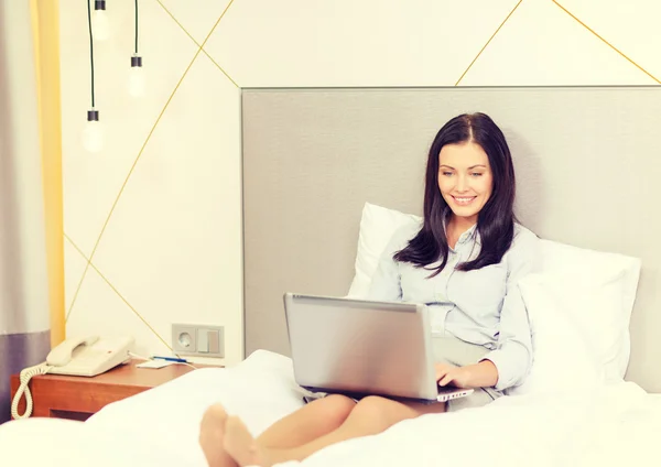 Donna d'affari felice con computer portatile in camera d'albergo — Foto Stock