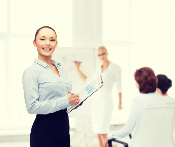 Young smiling businesswoman with clipboard and pen — Stock Photo, Image