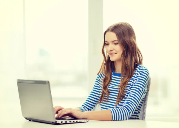 Sorrindo adolescente gitl com computador portátil em casa — Fotografia de Stock