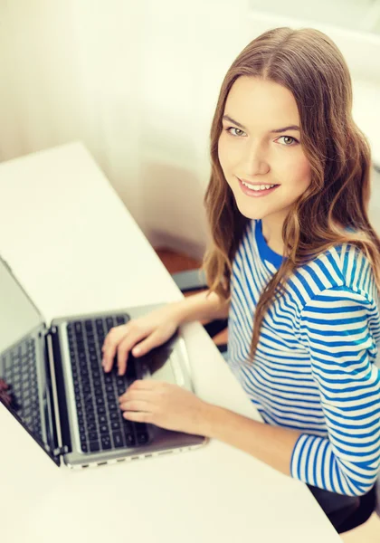 Sorridente adolescente gitl con computer portatile a casa — Foto Stock