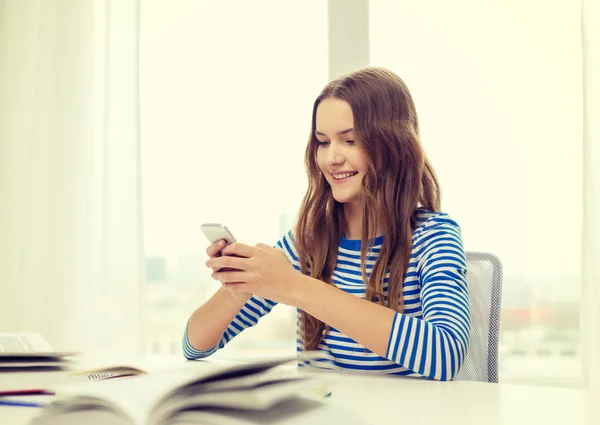 Lachende student meisje met smartphone en boeken — Stockfoto