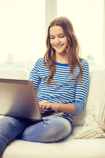 Sonriente adolescente con ordenador portátil en casa — Foto de Stock