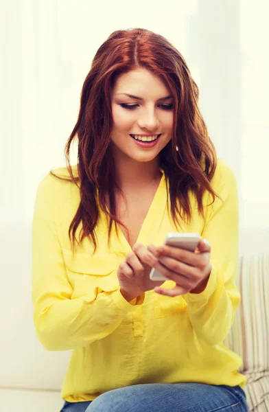 Lachende vrouw met smartphone thuis — Stockfoto