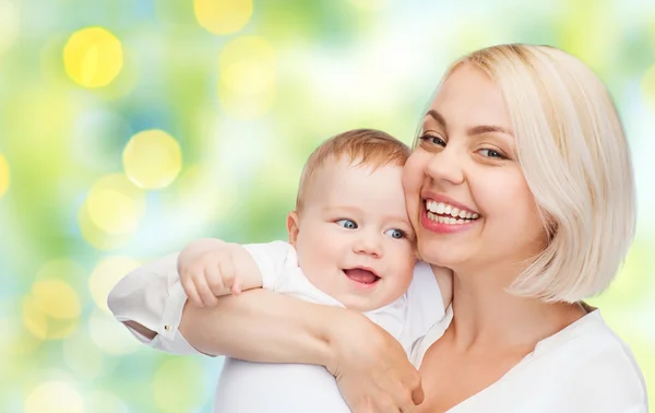 Mãe feliz com bebê sobre fundo verde — Fotografia de Stock