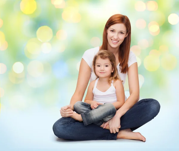 Madre feliz con niña sobre luces verdes —  Fotos de Stock