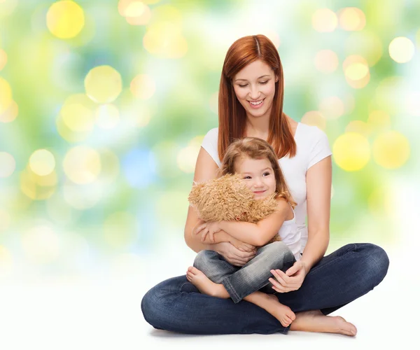 Mãe feliz com menina adorável e ursinho de pelúcia — Fotografia de Stock