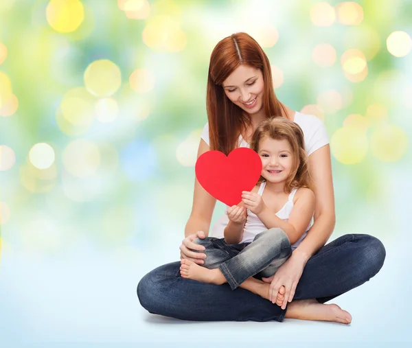 Gelukkig moeder met kleine meisje rood hart houden — Stockfoto