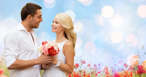 Feliz pareja con flores sobre las luces de fondo — Foto de Stock