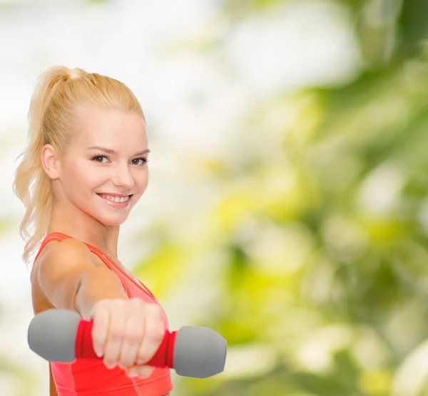 Sonriente hermosa mujer deportiva con mancuerna — Foto de Stock